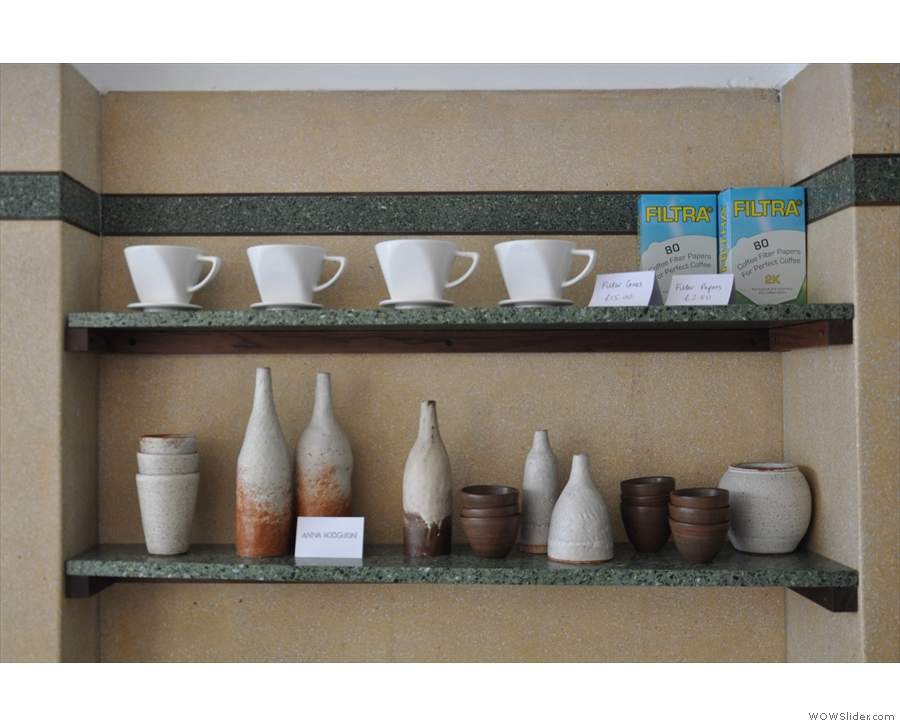 On the opposite side are two more retail shelves, with coffee kit and hand-made ceramics.