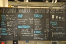 The comprehesnive menu is chalked up on cupboard doors behind and above the till.