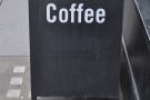 There's a solitary bench outside, with a solitary A-board & a solitary word on the A-board. However, if you can only have one word on your A-board, what better word than 'coffee'?
