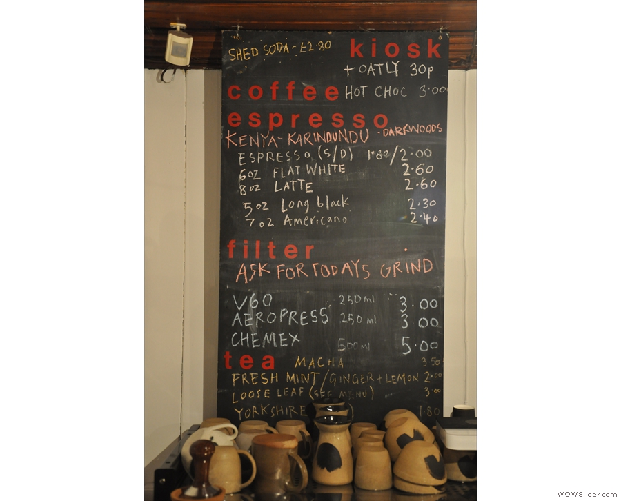 The concise coffee/tea menu is chalked up above the espresso machine.