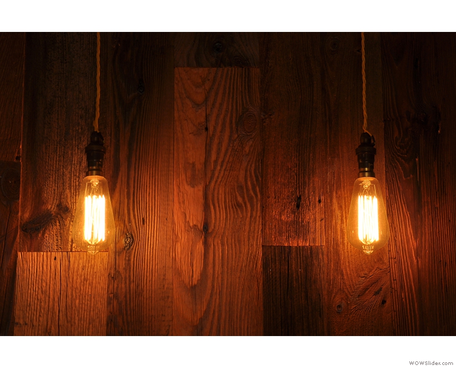 More bare light bulbs, this time to a backdrop of a wooden-clad wall.