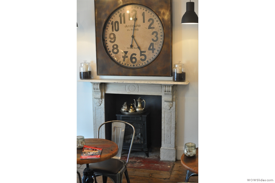The room is dominated by the fireplace, with its cast-iron stove and awesome clock!