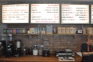 The coffee menus are on diner-style menus hanging on the wall behind the counter.