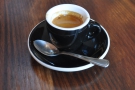My espresso on its own, in a classic, black cup.