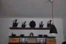 Meanwhile, on the wall at the back of the counter, are some traditional coffee pots.