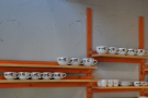 The cups line up on the wall behind the counter, waiting their turn to be used.