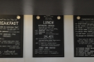 The menus hang on the wall behind and above the counter...