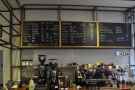 The espresso machine and grinders are on the back wall, menu above.