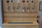 The fridge holds cold beer, but this caught my eye: a line of beer taps, bottles above.