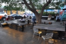A concrete-topped table forms in a near square, seating provided by benches & chairs.
