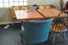 There's a smalerl wooden bench seat next to it with two smaller tables.