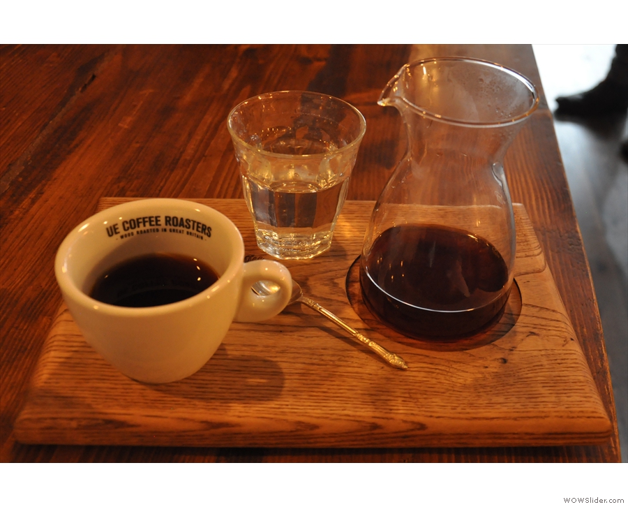 The coffee is poured in a carafe, with a cup on the side and a glass of water.