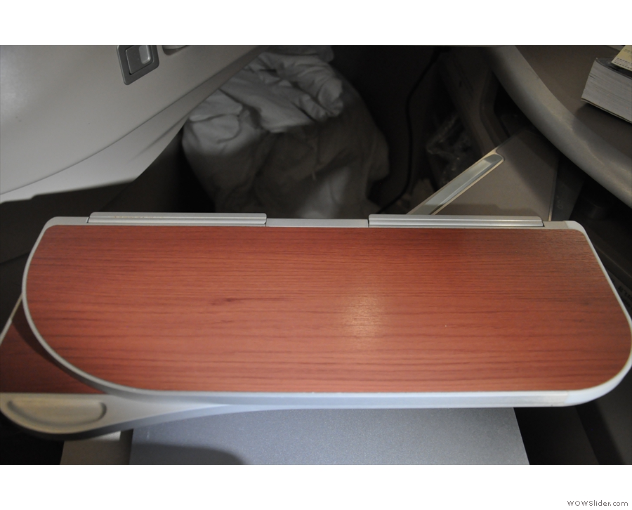 The table hinges out, like in the 787, from the console at the side...