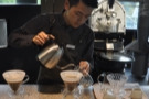 While the two V60s are brewing, the barista prepares the carafes and cups, warming them.