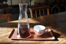 My coffee in the sun, served in the beaker, with a cup on the side, all on a little tray.