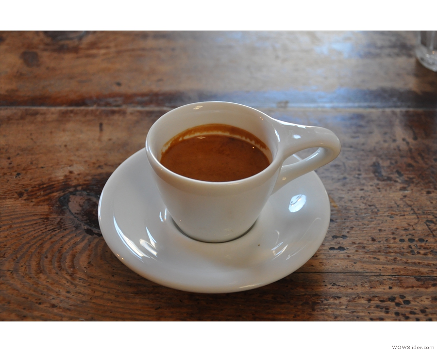 ... and the resulting espresso, served in a classic white cup with oversized handle.