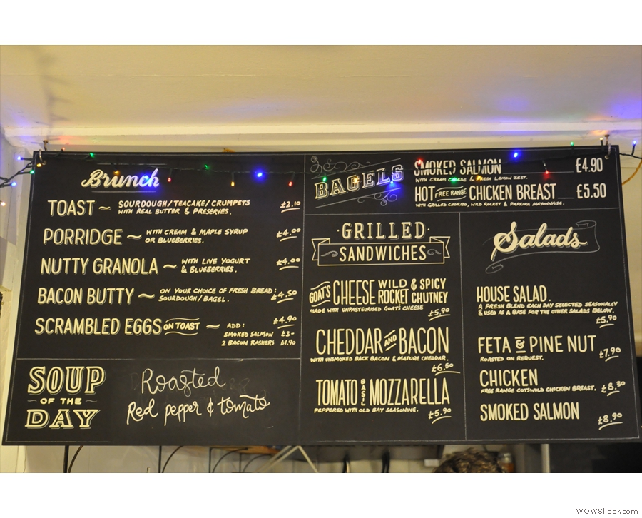 The menus are displayed on blackboards above the counter, with food on the left...