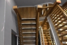 ... a central, wooden stairwell which heads down, doubling back on itself.