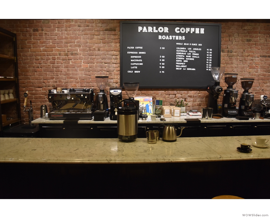 The counter has a central menu on the back wall, flanked by two espresso machines.