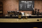 The counter has a central menu on the back wall, flanked by two espresso machines.