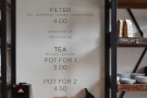 The simplified drinks menu is on the wall behind the till...