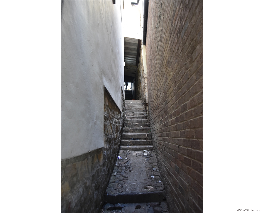... beyond which a narrow staircase between buildings leads up to Saddler Street...