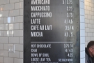 The coffee menu is on a pillar to the right of the till...