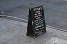 ... while the A-board cuts a solitary figure on the veritable expanse of pavement.