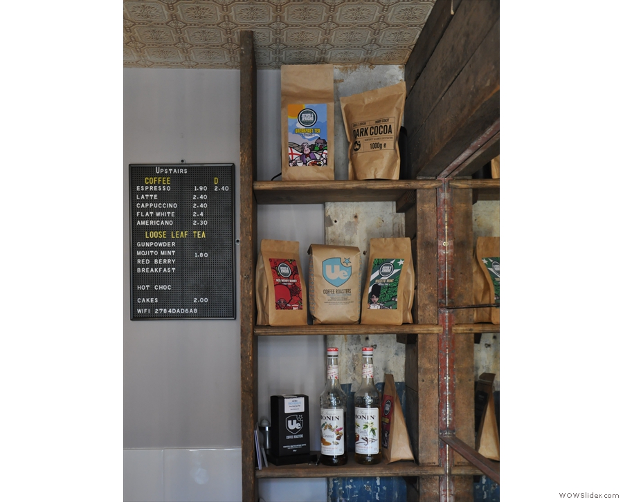 During Upstairs Coffee days, the menu was on the back wall, next to some narrow shelves.