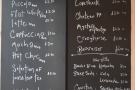 A simple menu is chalked on the wall behind the counter.