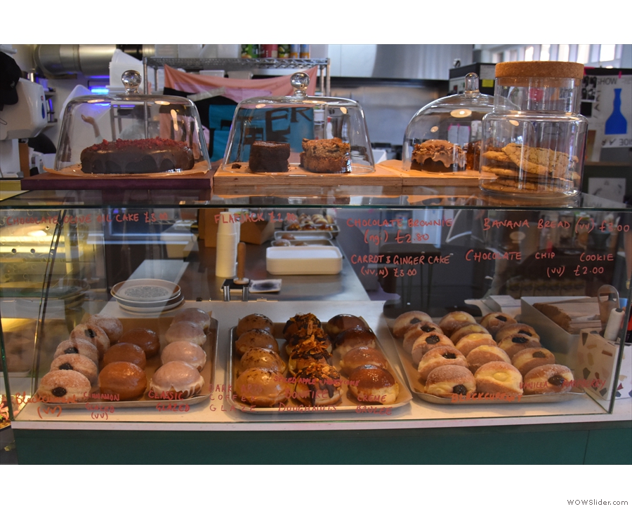 There is a large display case to the left of the till which contains the cakes on top...