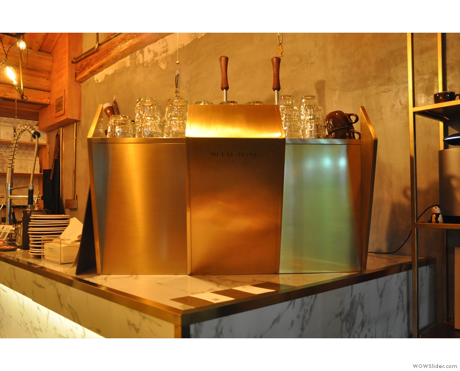 Stepping inside, you're immediately greeted by the gleaming metal espresso machine...