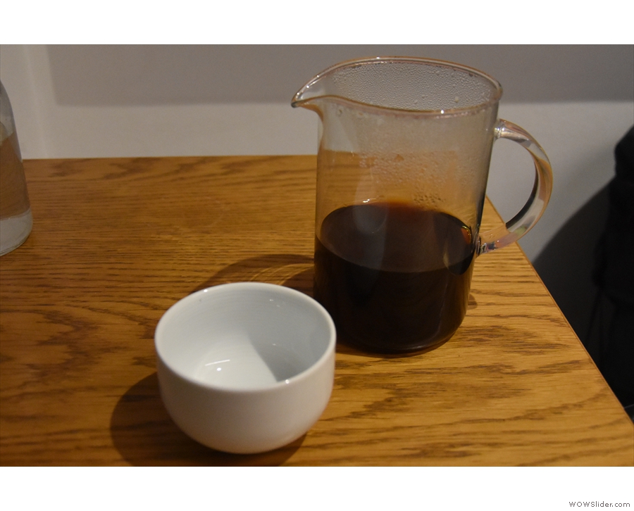My coffee, served in a glass jug with a cup on the side.