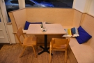 A long wooden bench runs in a C-shape, with this four-person table at the front...