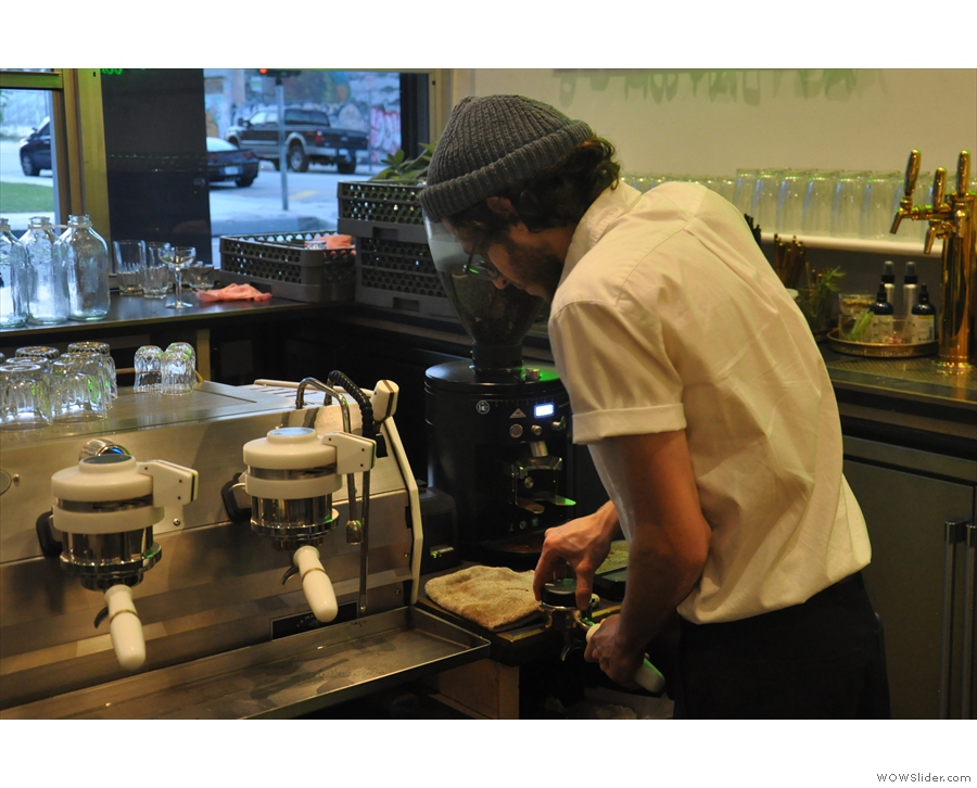 Here's the barista making my 5oz with milk. Step one, grind and tamp the coffee...