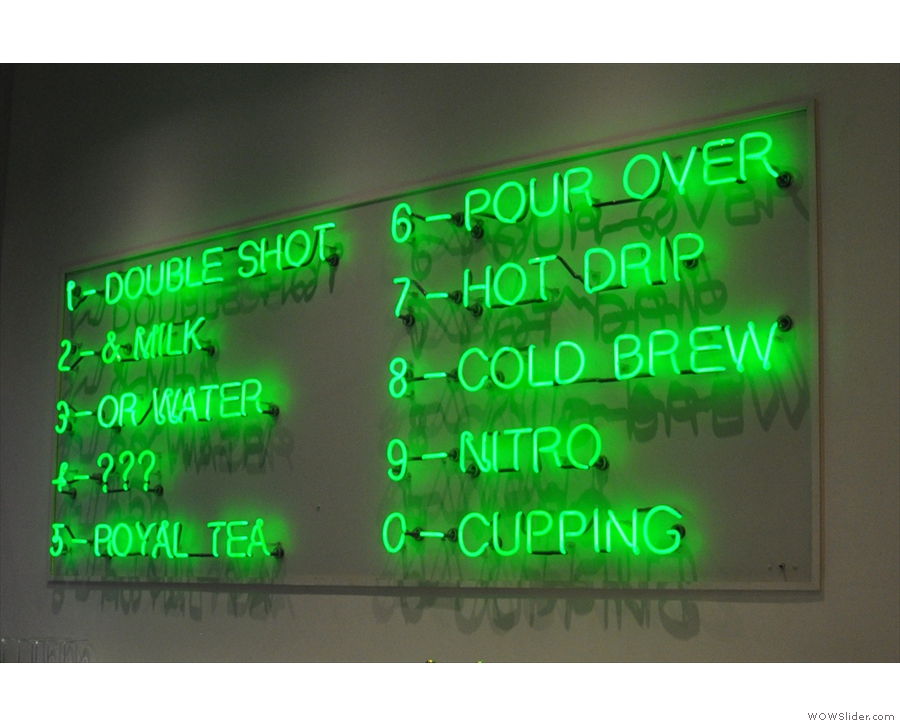 The drinks menu, in green neon, is on the wall behind the counter...