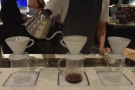 ... with the barista varying the height of the spout above the surface of the coffee.