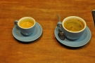 An espresso and an americano being prepared for other customers. I love the blue cups.