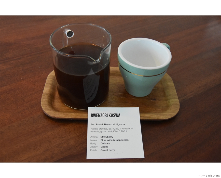 ... served in a carafe with a cup on the side, presented on a tray with an information card.