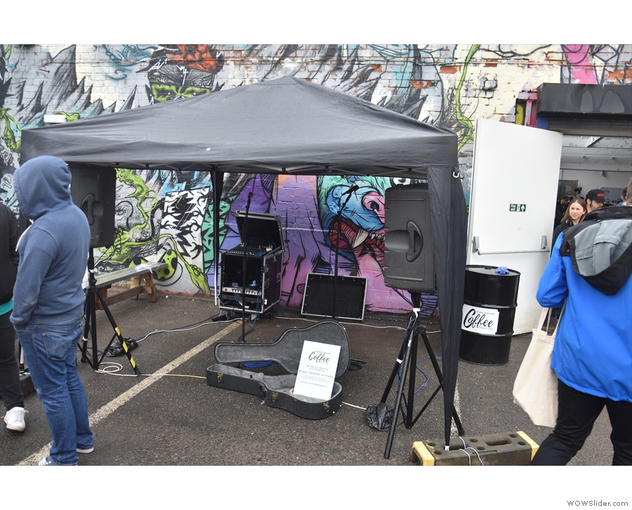 The buskers' stage had also been moved out here, with a gazebo protecting the...