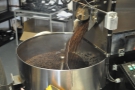 The sluice is opened and hot, just-roasted beans pour out into the cooling pan.