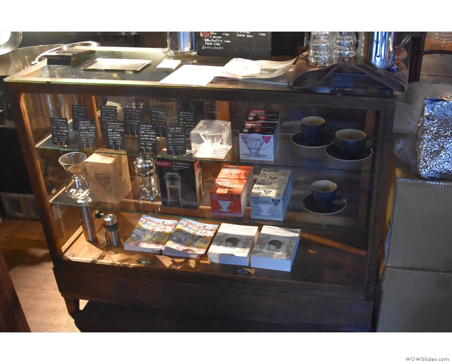 The counter incorporates a glass display case with various coffee kit for sale.