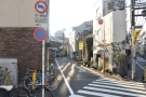 In the tangle of narrow streets north of Shibuya Station, stands (on the left)...