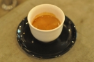 An interesting twist; classic black saucer, but white, handless cup.