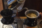 Note how the barista moves the kettle around the surface of the coffee...
