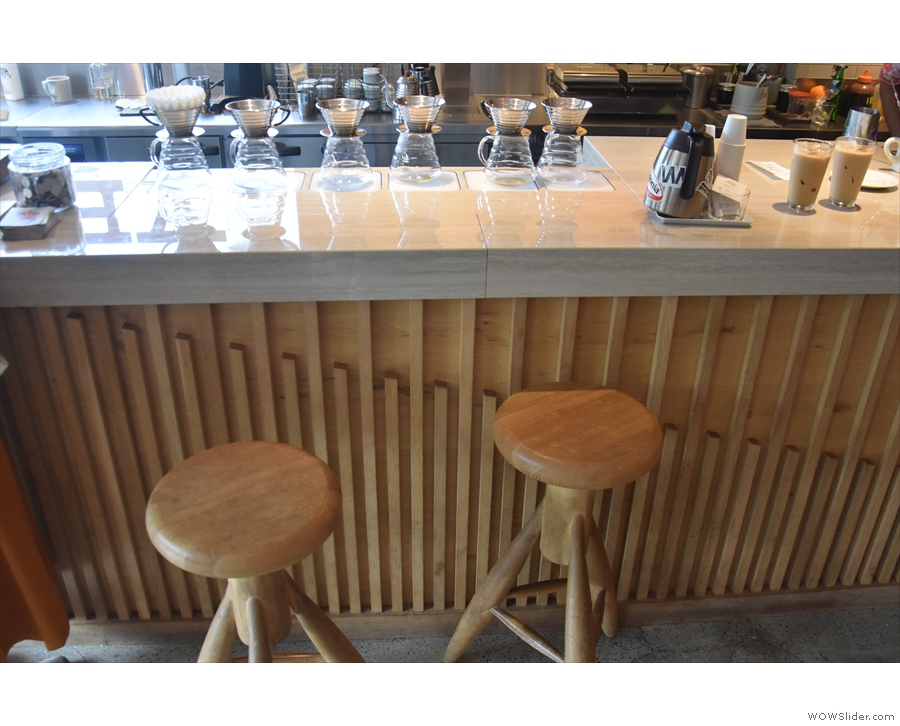 There are a pair of stools by the counter, next to the pour-over station.