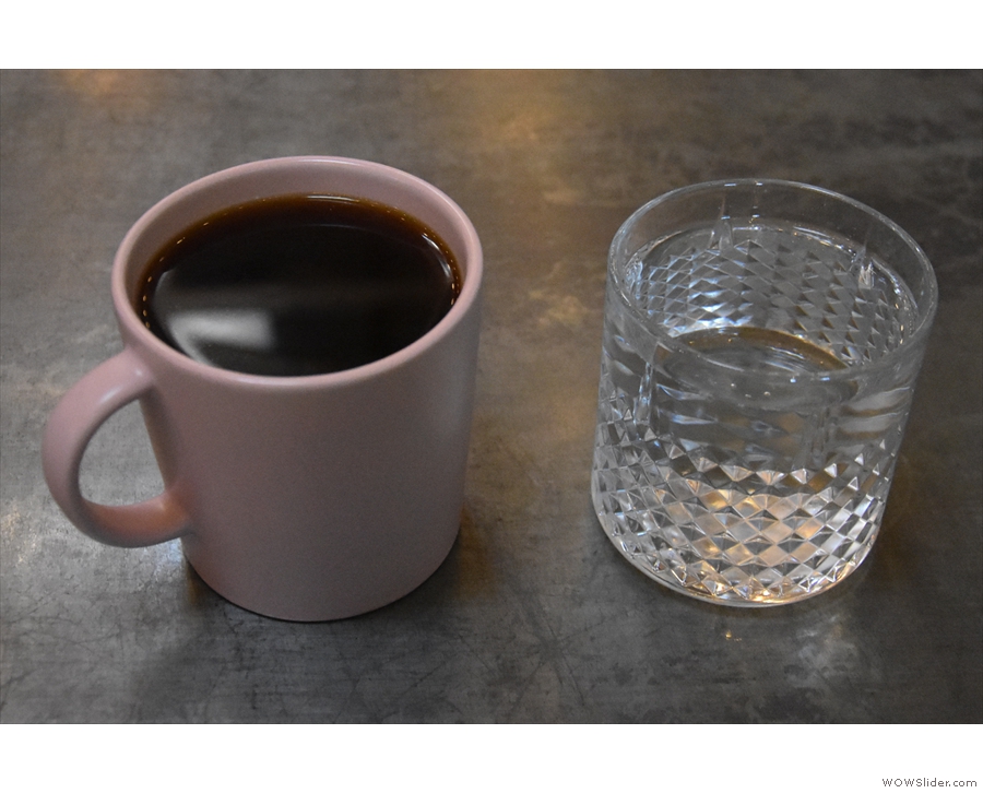 After the coffee has filtered through, it's served in a mug along with a glass of water.