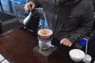 Next comes the first pour, where Kimhak fills the filter to the top...