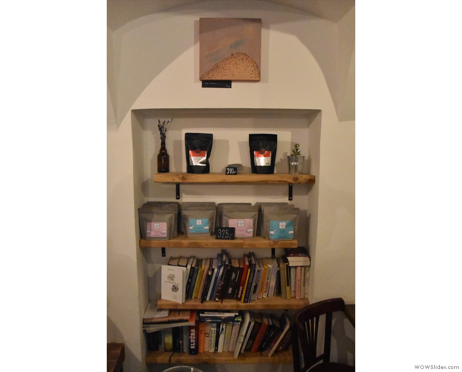 An alcove in the far wall is lined with shelves. There are books on the lower shelves...