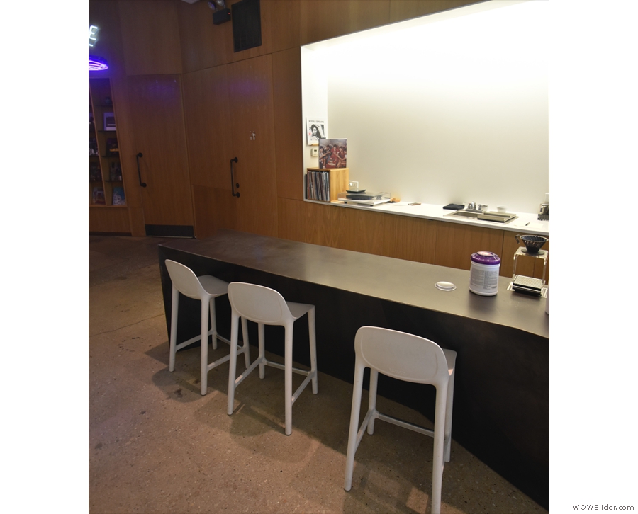 ... a row of three high-backed chairs tucked under an extension at the counter's far end.